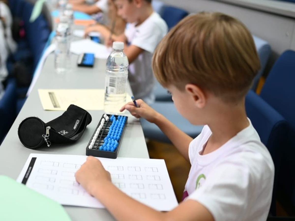 Učenik računa na plavom abakusu uz radni list